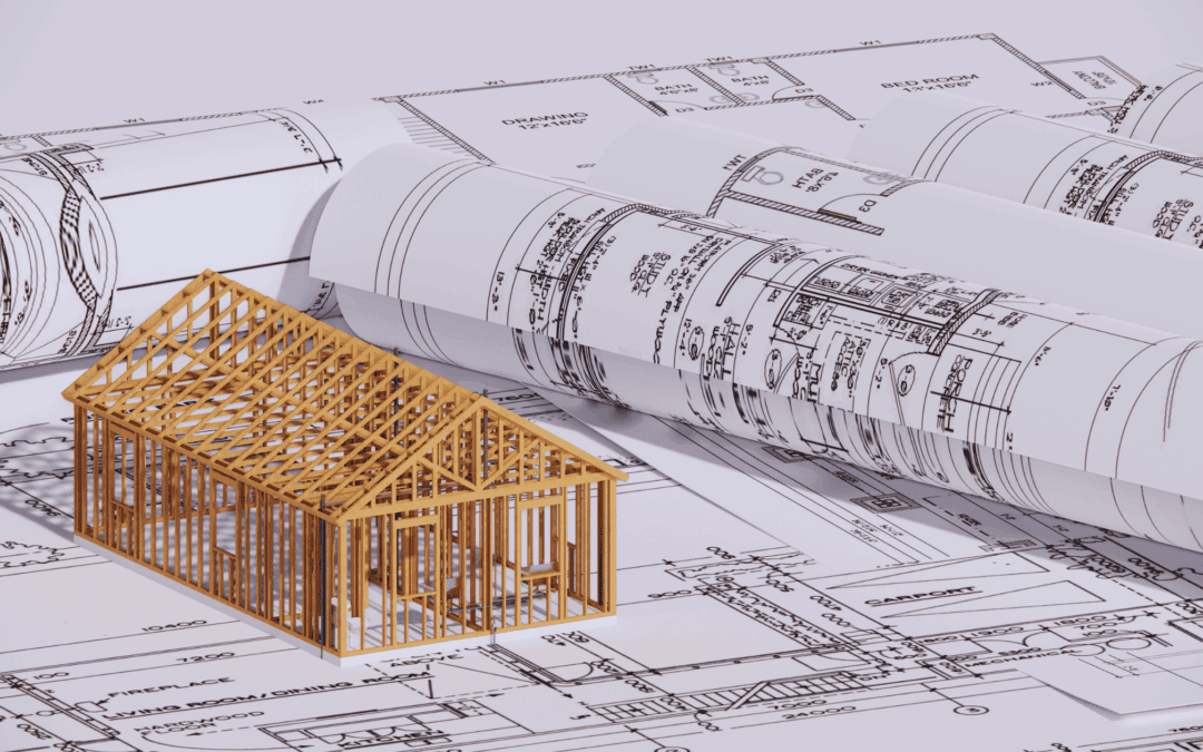 Wooden house frame model on architectural blueprints for construction planning.