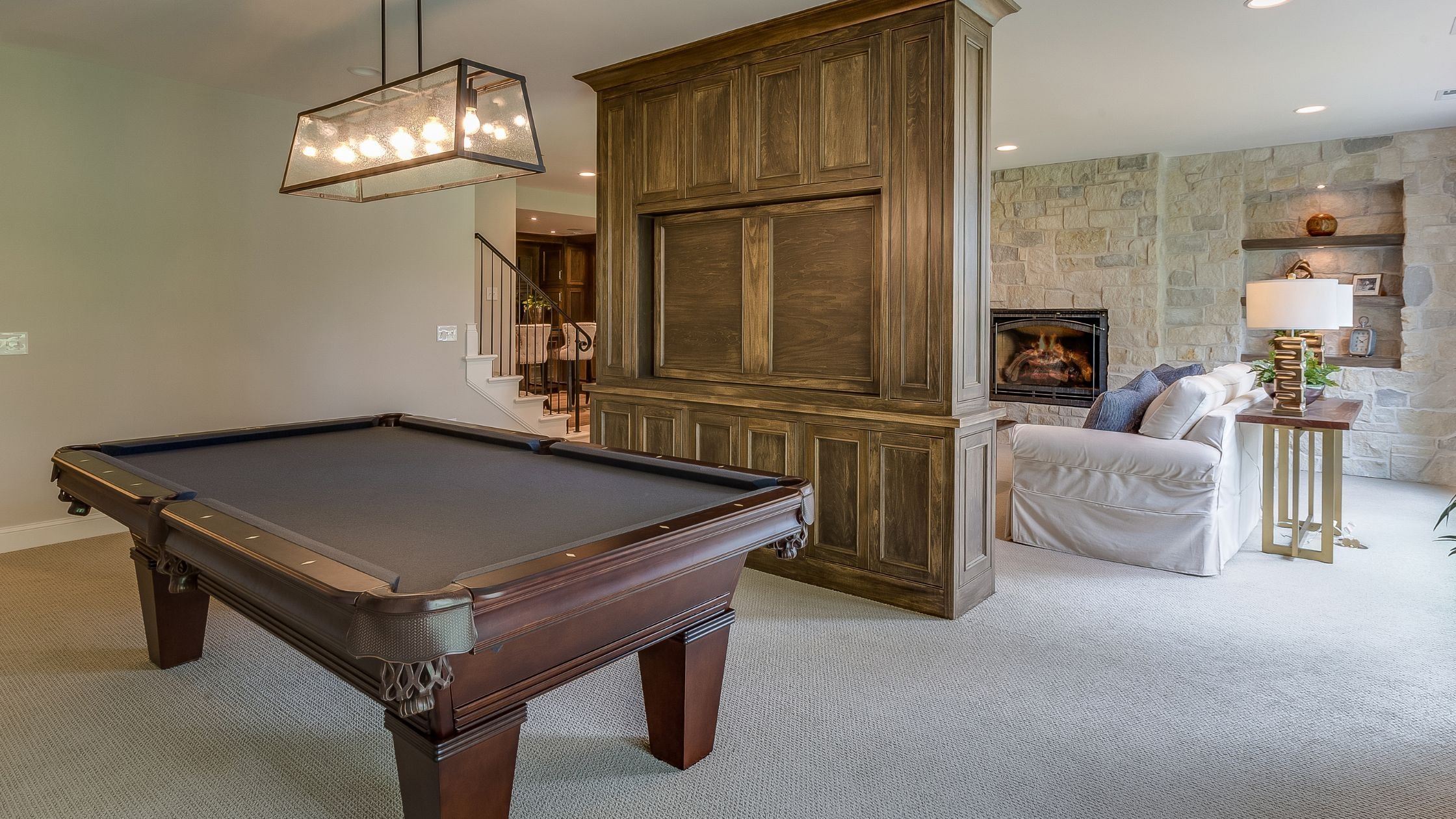 Elegant game room with a classic pool table and cozy seating area. Perfect for entertainment and rel.