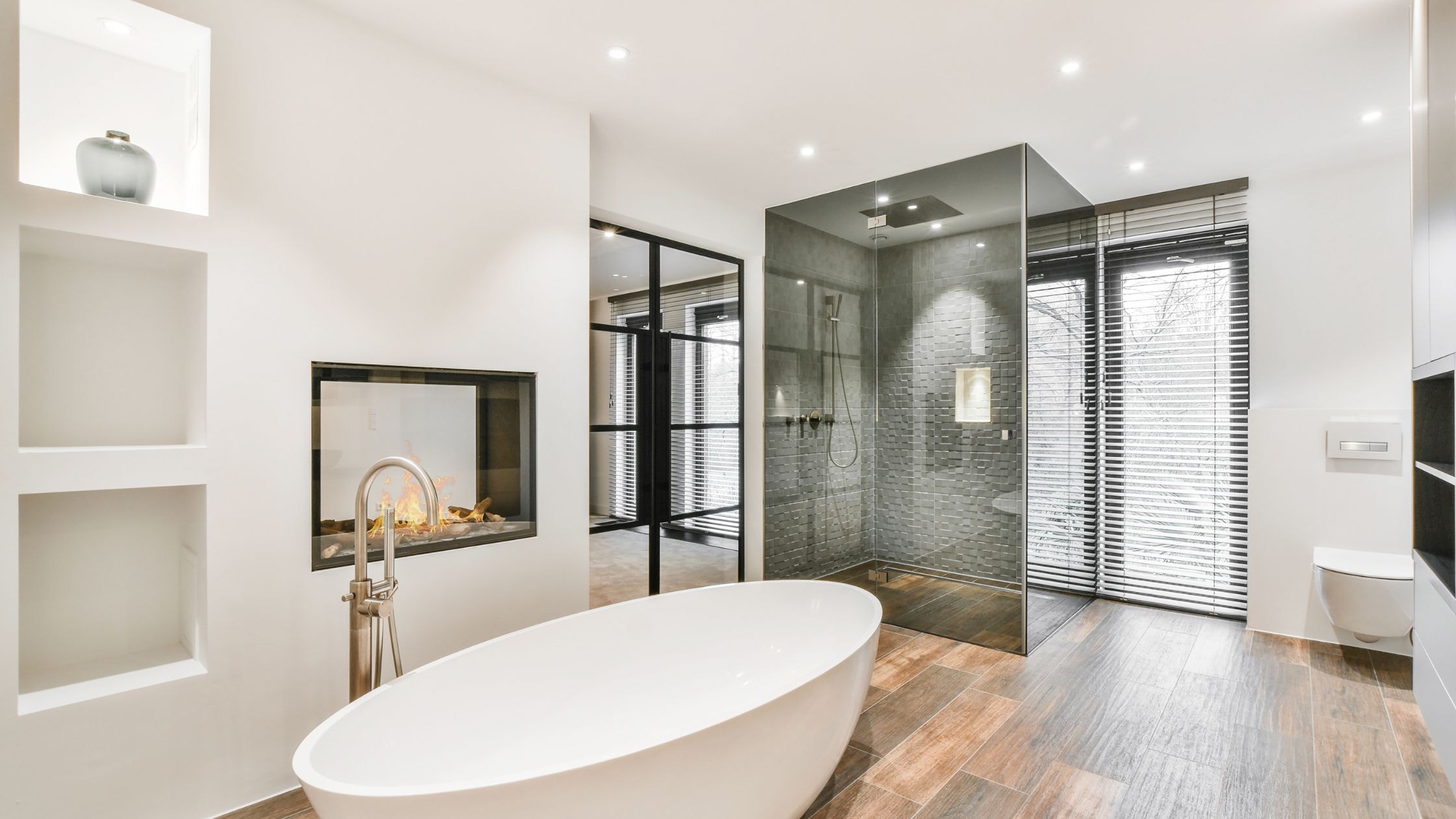 Elegant modern bathroom with freestanding tub and glass shower enclosure.
