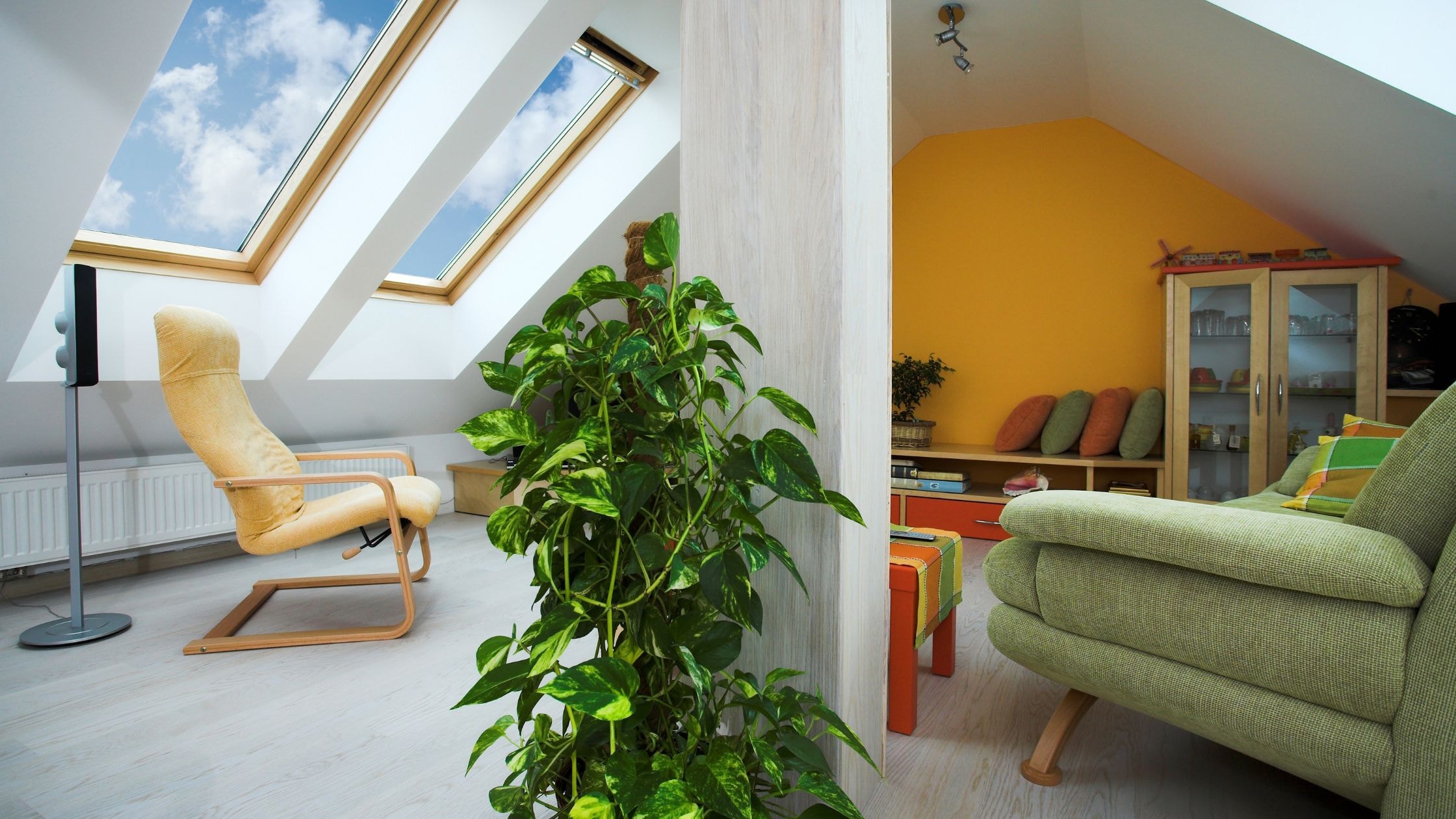 Bright attic living space with large skylights and comfortable seating.