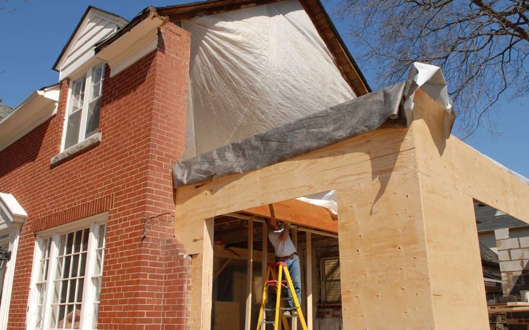 Image of a house under construction showing brick exterior and wooden framing.