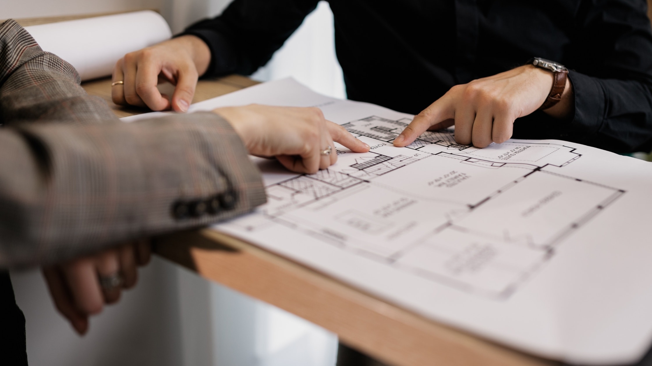 Two professionals reviewing architectural blueprints during a planning session.
