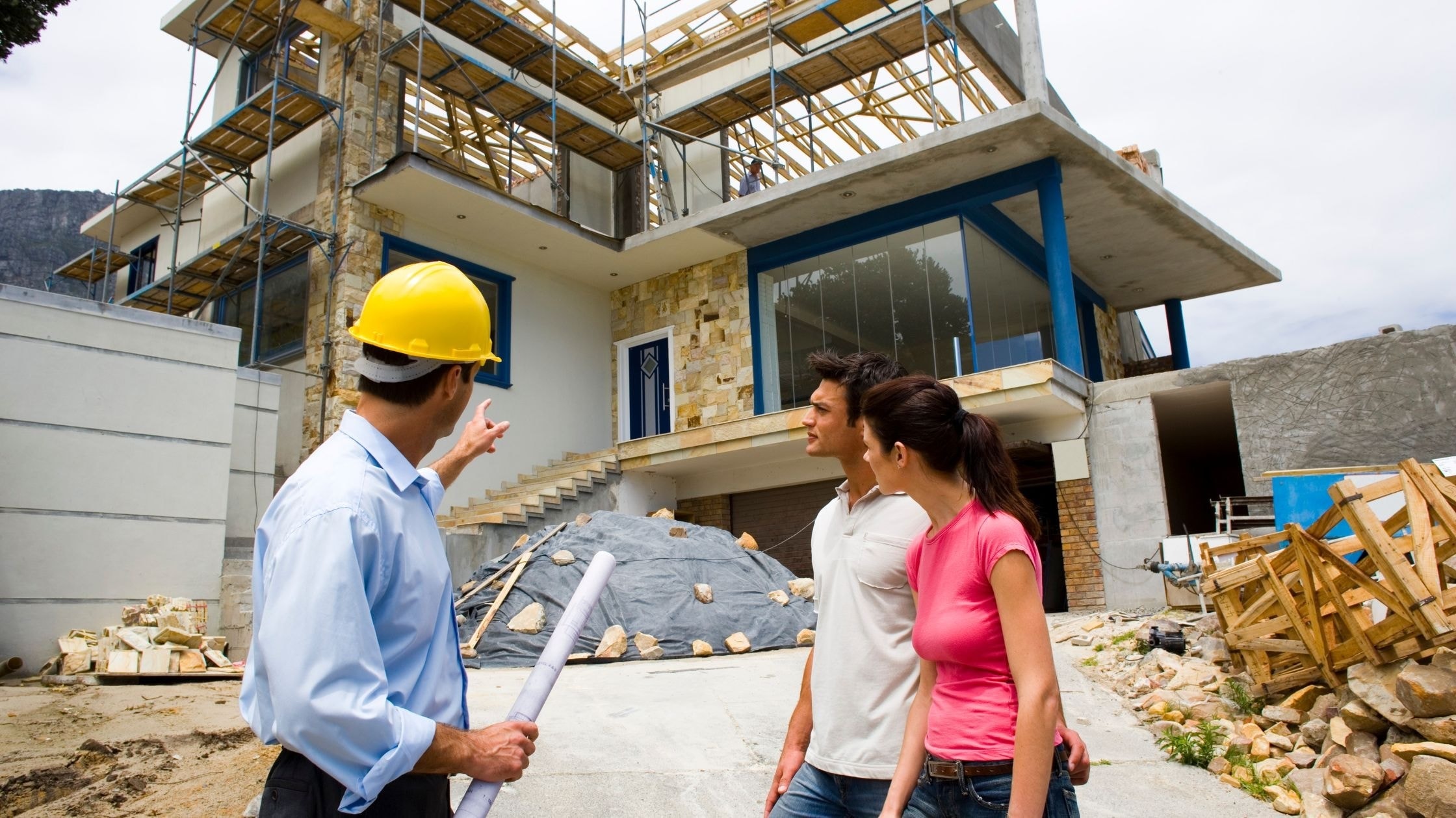 Construction workers discussing a new modern house under building.