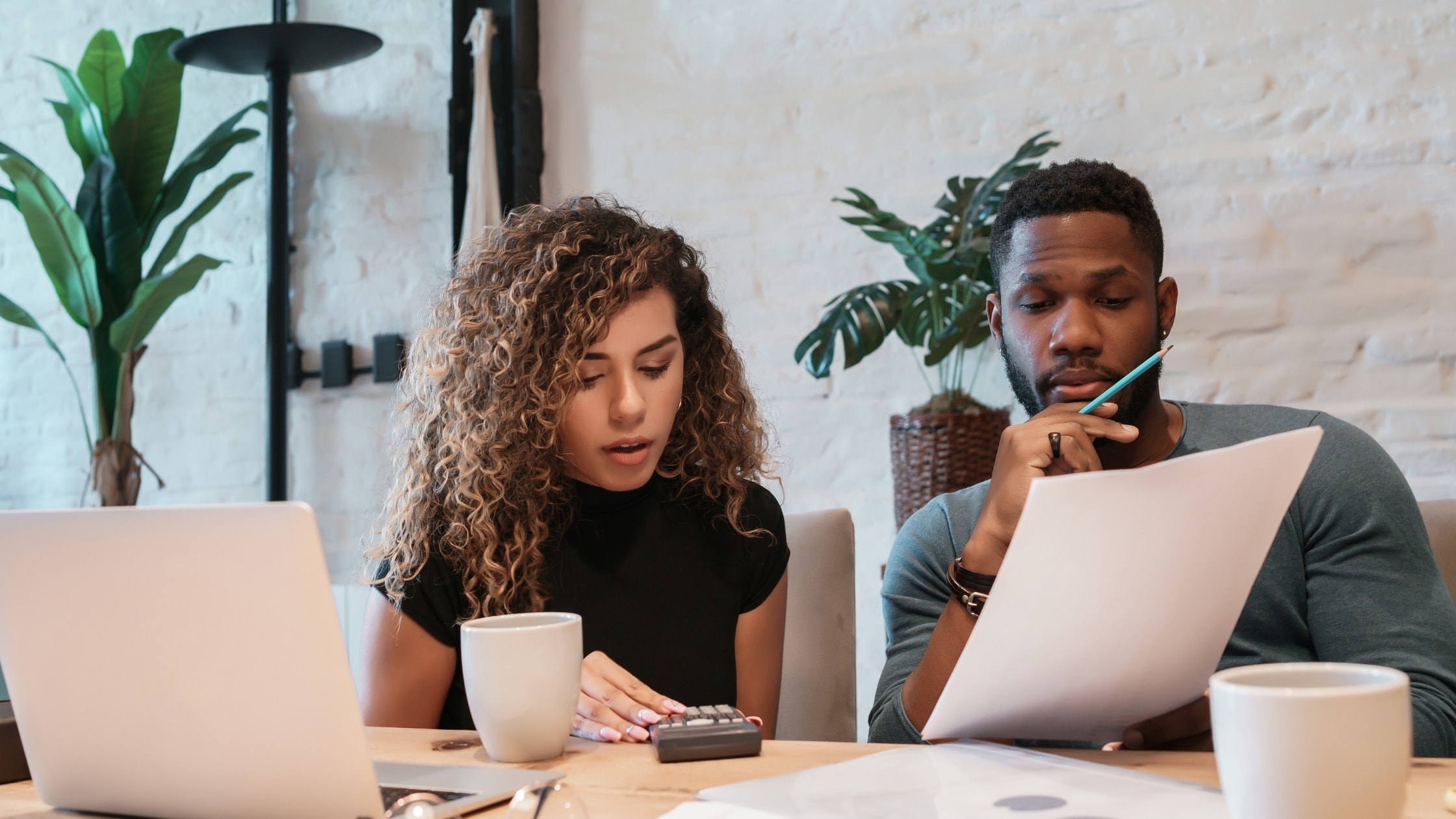 Two colleagues reviewing documents and discussing in a modern office setting.