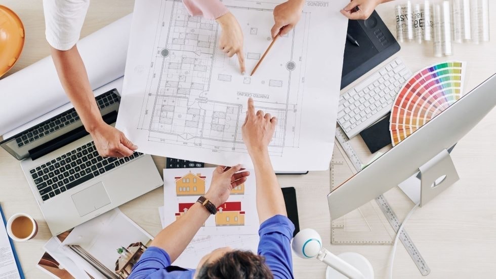 Team reviewing architectural plans for a custom home construction project.