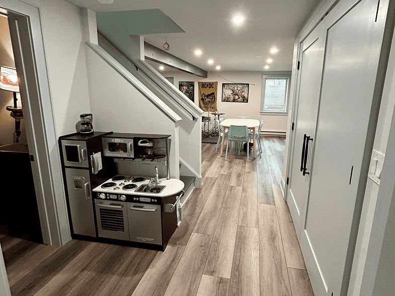 Child's play area with mini kitchen and colorful artwork on the wall.