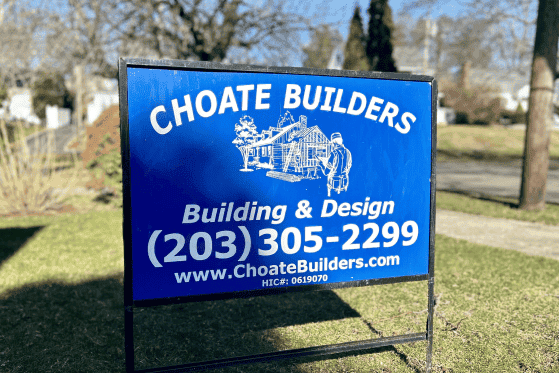Sign for Choate Builders showcasing building and design services in a residential neighborhood.