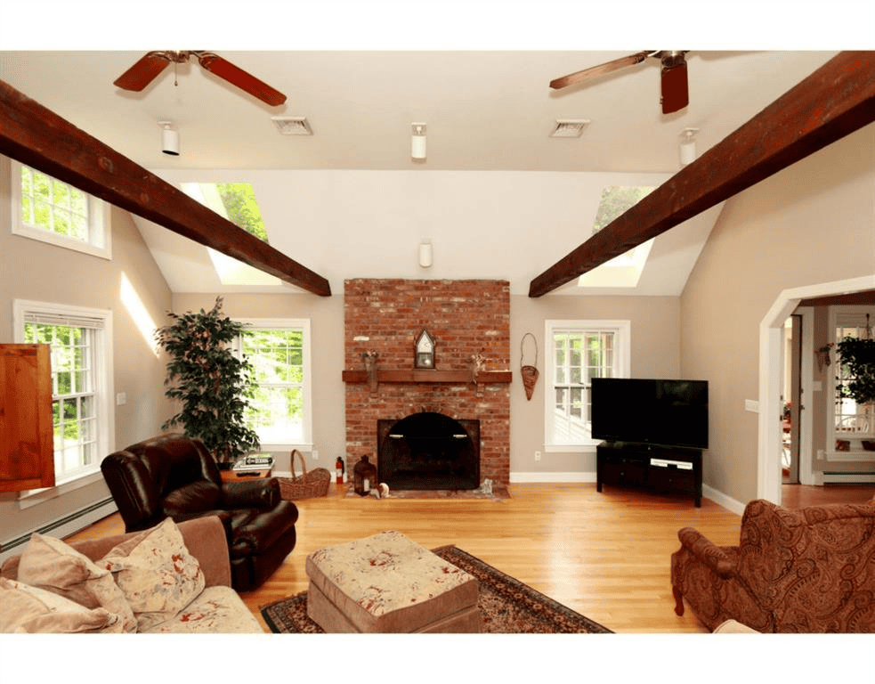 Bright living room with brick fireplace and large windows.