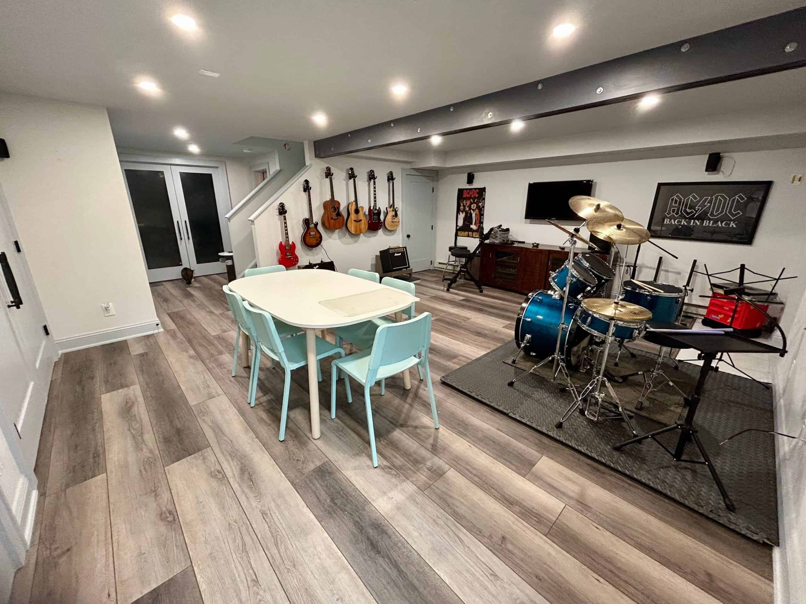 Modern music room with guitars and drum set for home entertainment.