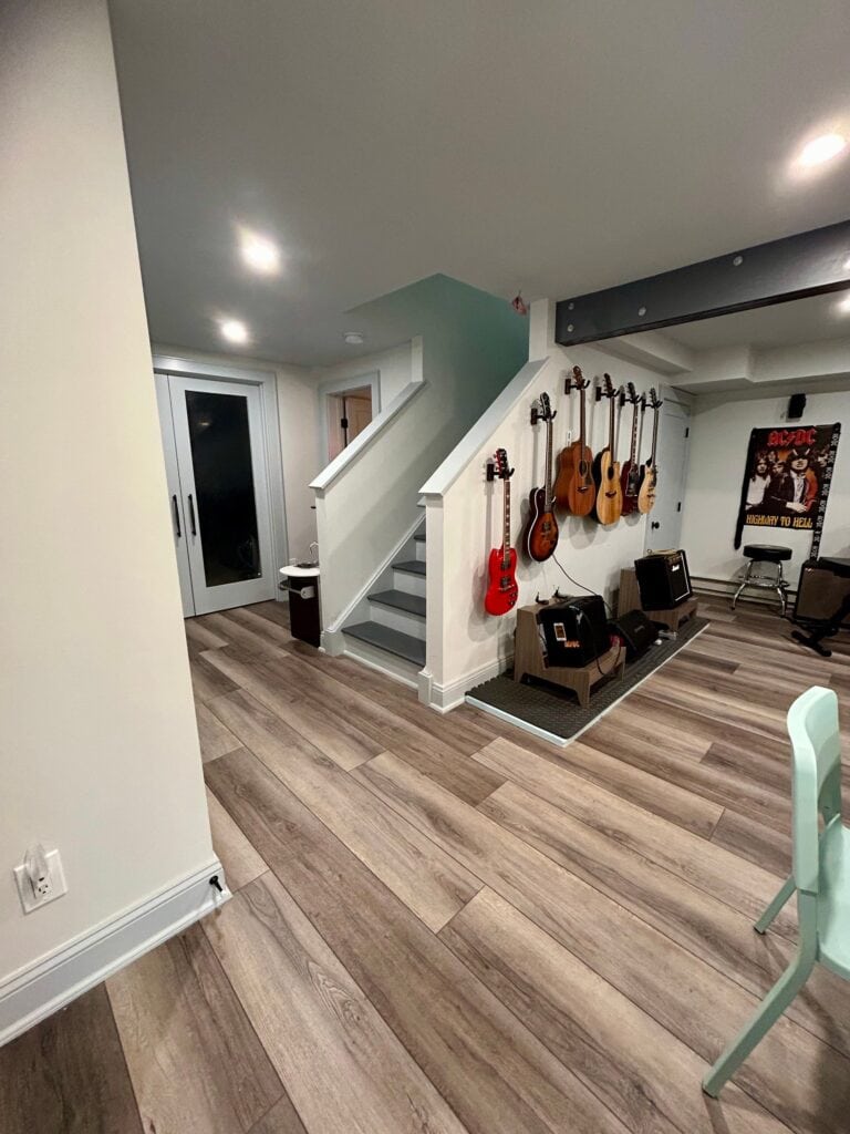 Interior of a music room featuring guitars on the wall and audio equipment.