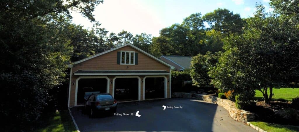 New residential garage with driveway and surrounding greenery at Example Co.