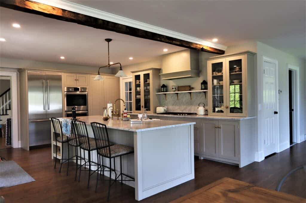 Spacious modern kitchen with white cabinetry, stainless steel appliances, and a large island for coo.