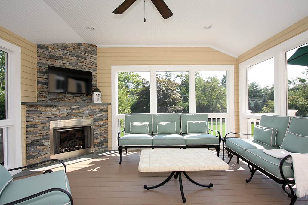 Bright sunroom with comfortable seating and large windows.