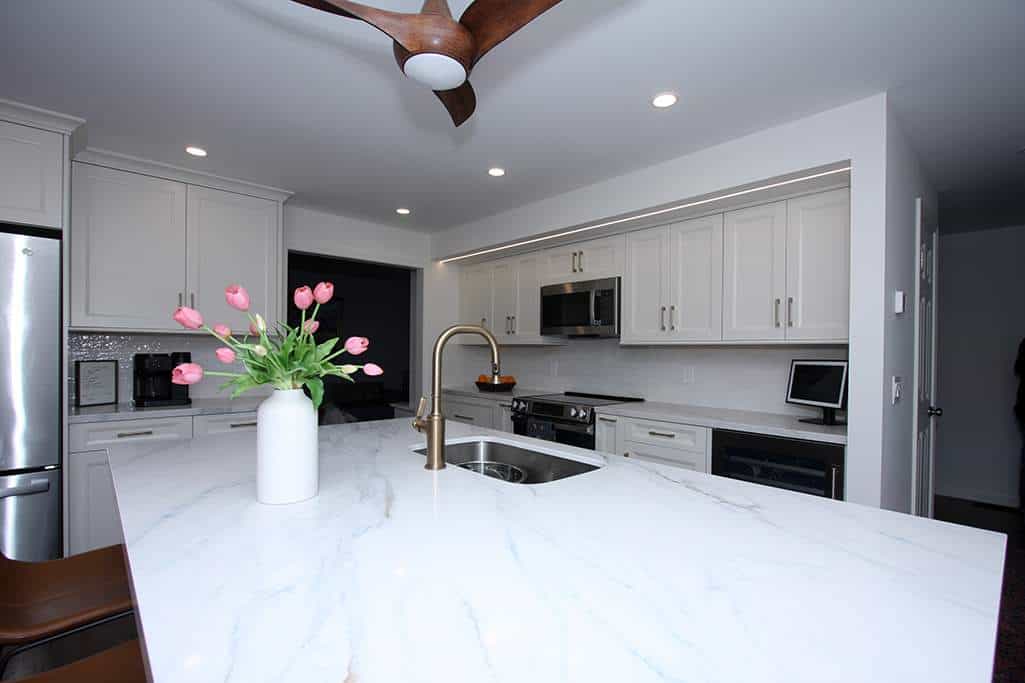 Kitchen with white cabinets and marble countertops.