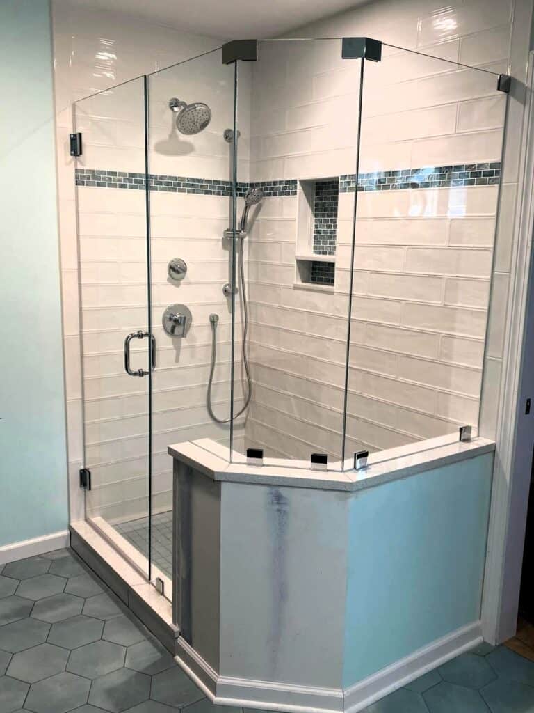 Glass shower door with sleek hardware and tiled interior.