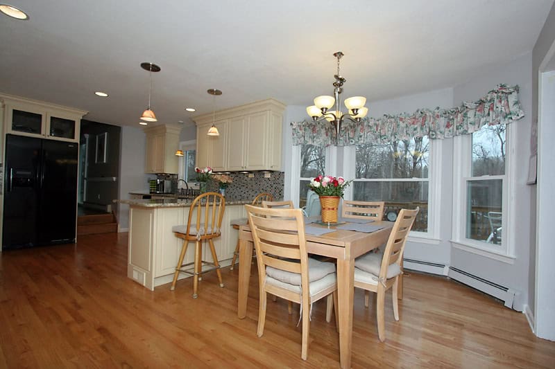 Bright, open-concept kitchen with a cozy dining space featuring natural light and stylish decor.
