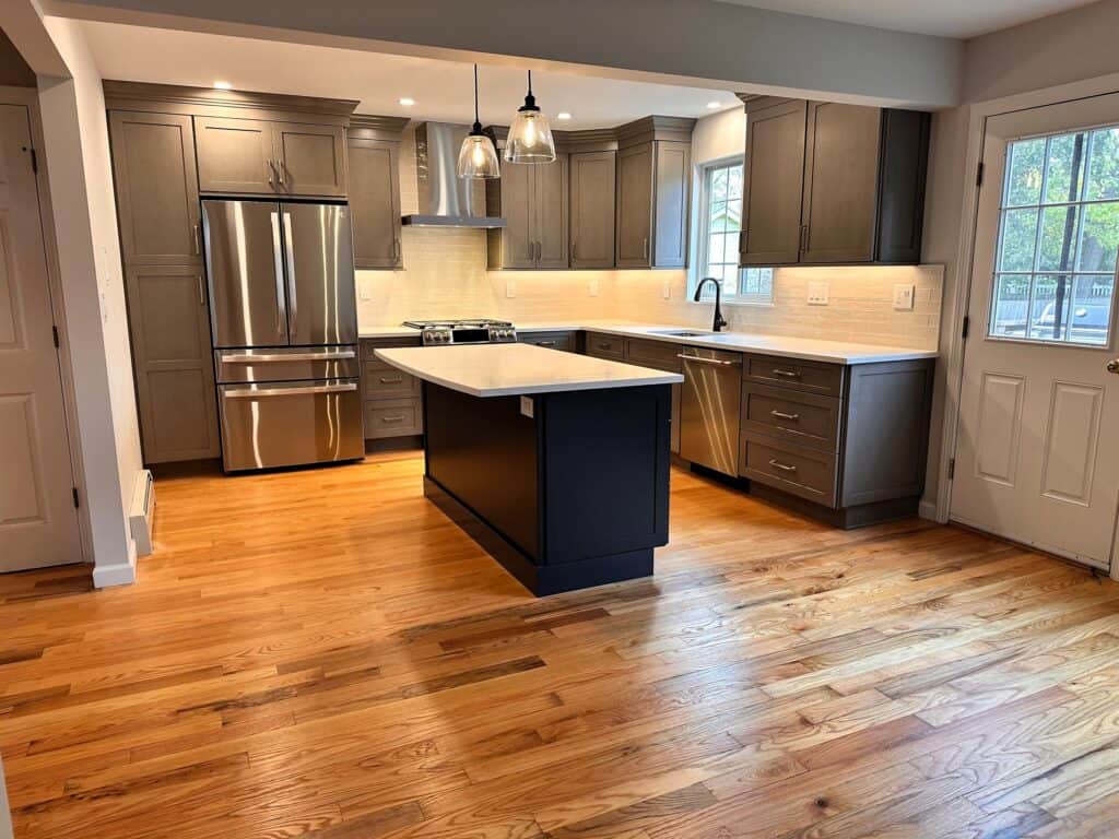 Modern kitchen with gray cabinets and stainless steel appliances.
