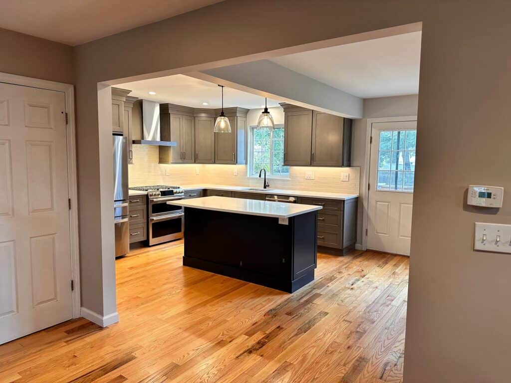 Bright and spacious kitchen with dark cabinetry and a central island. Features stainless steel appli.