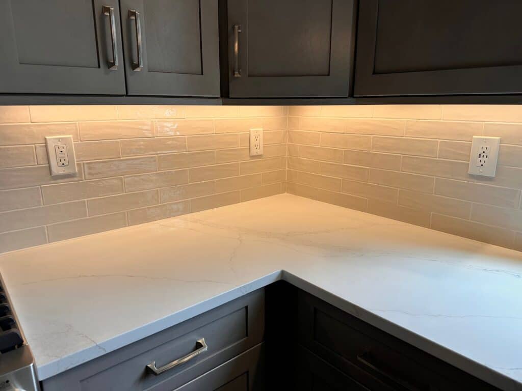 Kitchen countertop with gray cabinets and backsplash for modern home design.