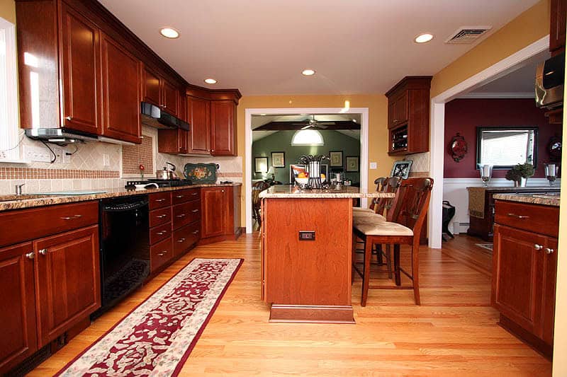 Beautiful modern kitchen with rich wooden cabinets and hardwood flooring.