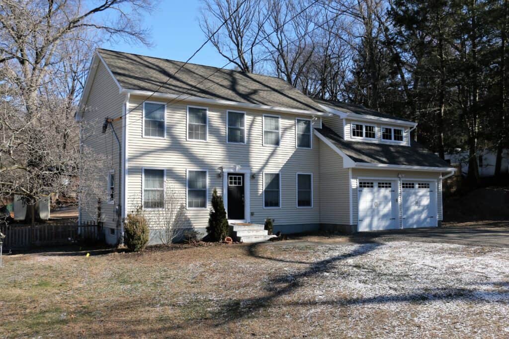 Beautiful two-story house with white siding, large windows, and attached garage in a suburban settin.