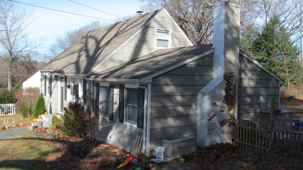Charming residential house with a chimney, surrounded by trees and garden.