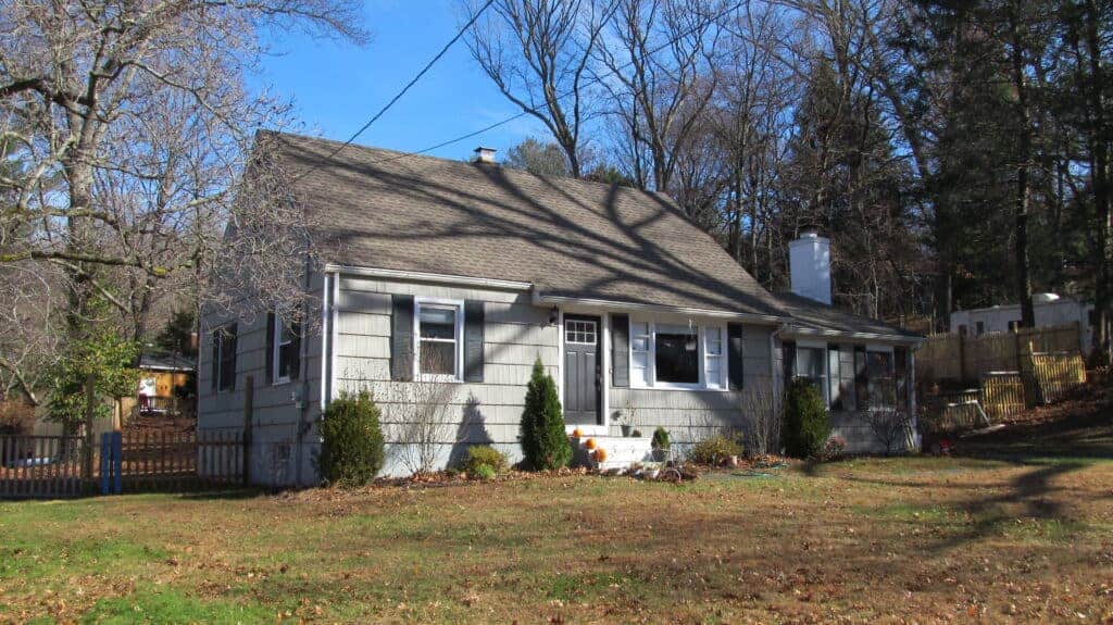 Charming home with a well-maintained yard, surrounded by trees, showcasing quality construction and.