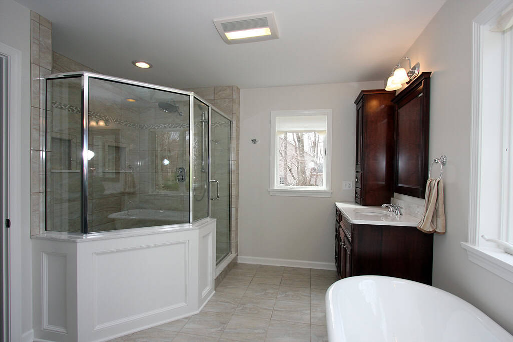 Bathroom with glass shower enclosure and bathtub.