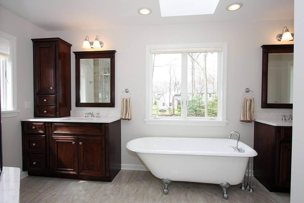 Elegant bathroom with a classic clawfoot tub and dark wood cabinetry.