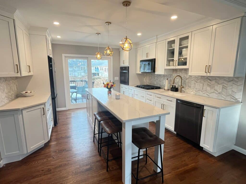 Modern white kitchen with island and pendant lighting.