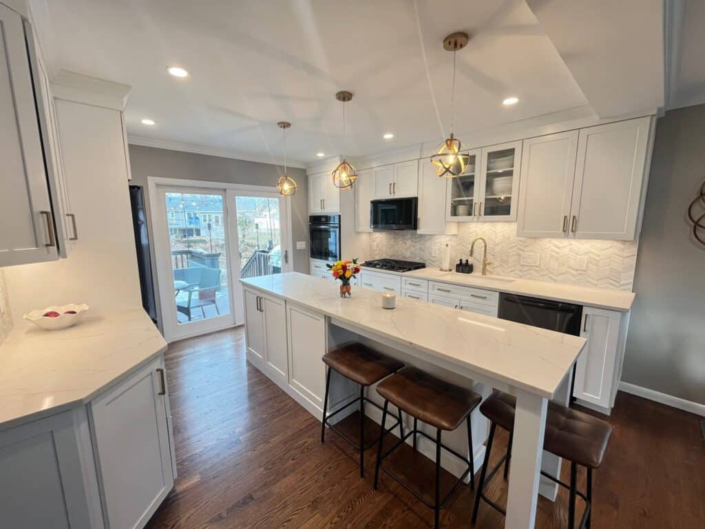 Bright modern kitchen with white cabinets, island, and pendant lighting.