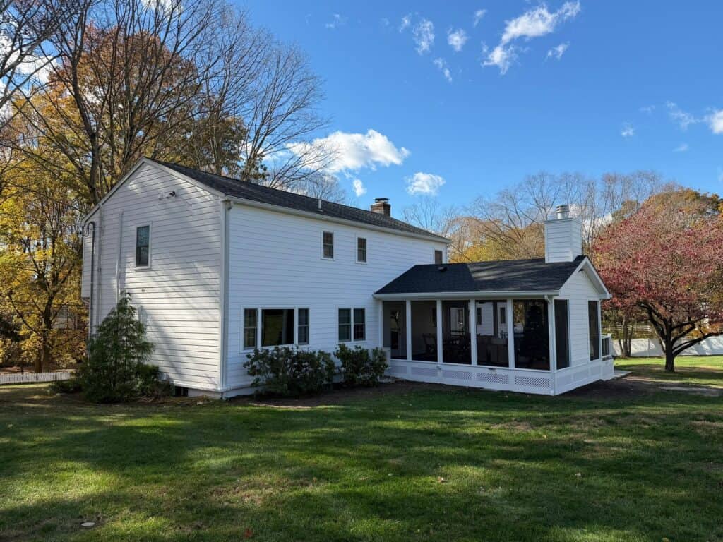 Beautiful modern white house with a spacious porch and lush green lawn.