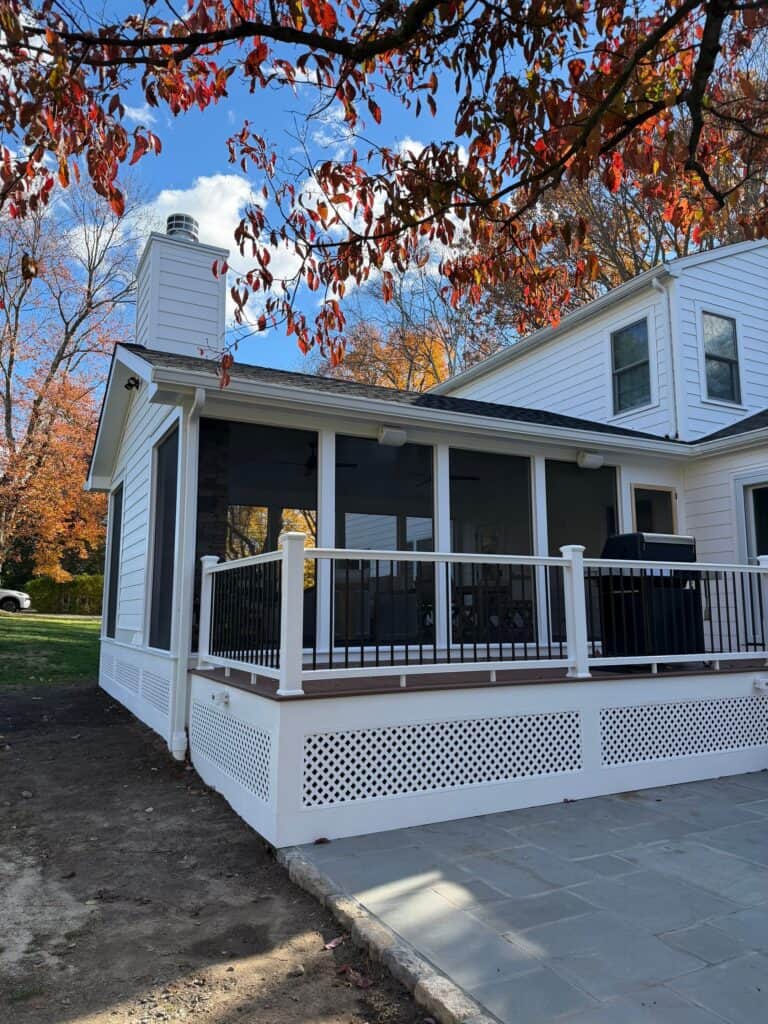 White screened porch with black accents and lattice skirting.