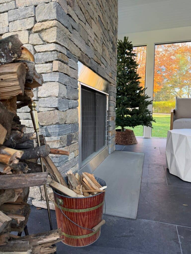 Fireplace with stone surround and wood storage.