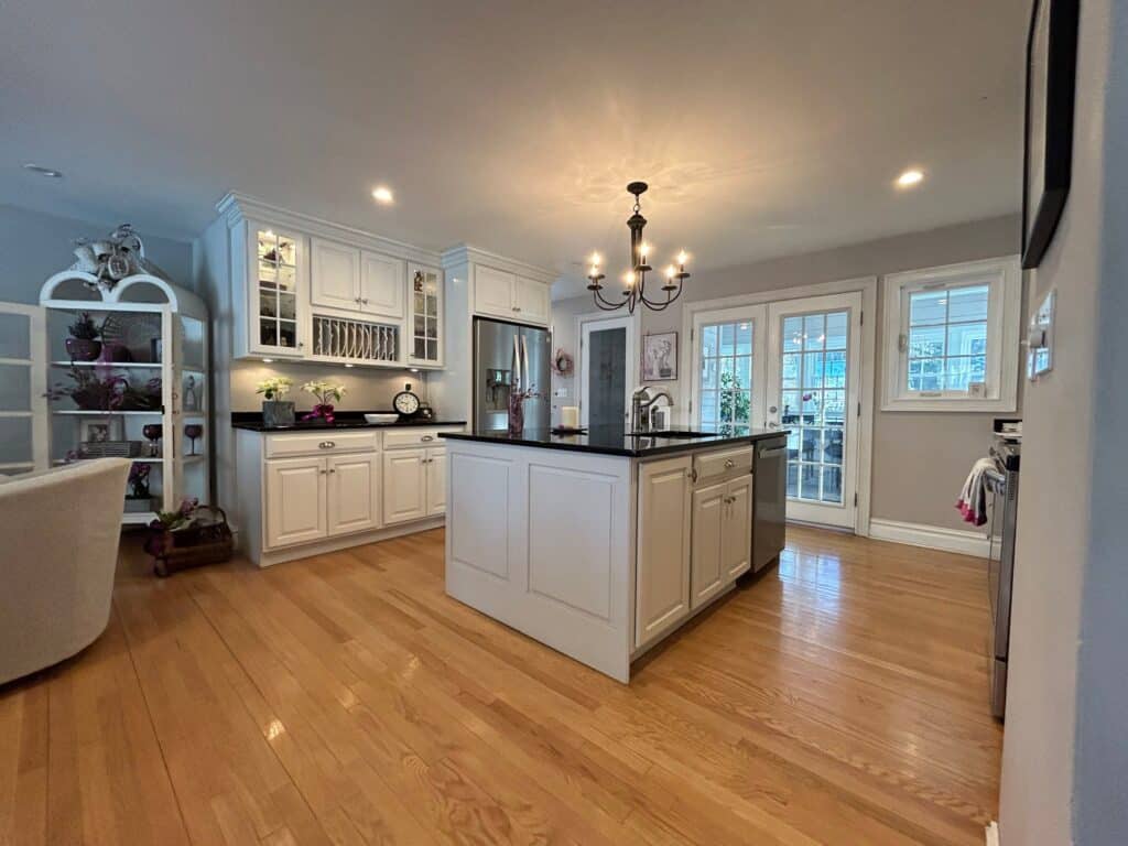 Modern kitchen with white cabinetry and black countertops.