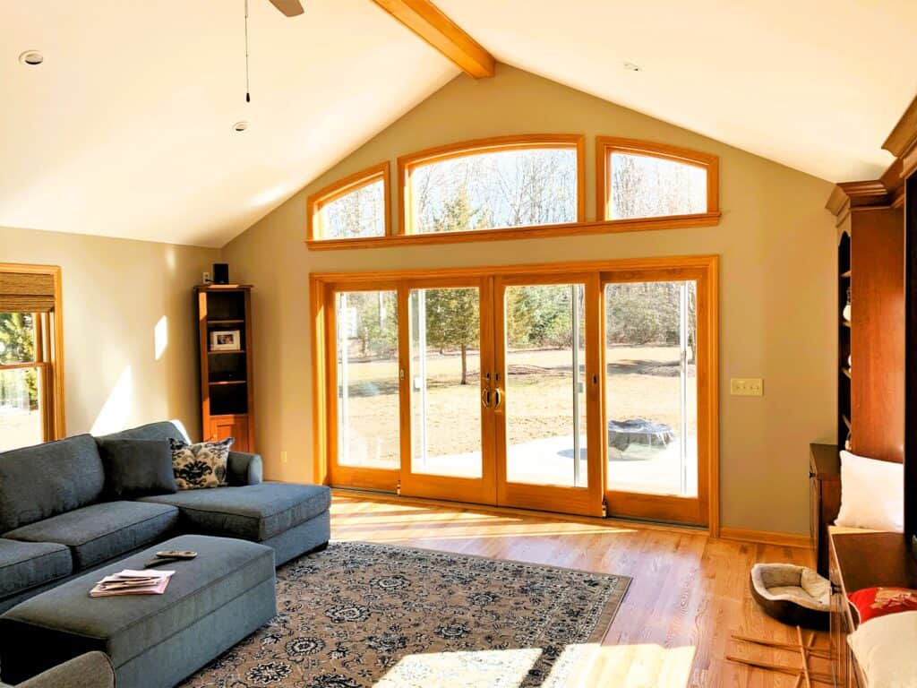 Large living room with expansive windows and natural light, featuring a comfortable sectional sofa a.