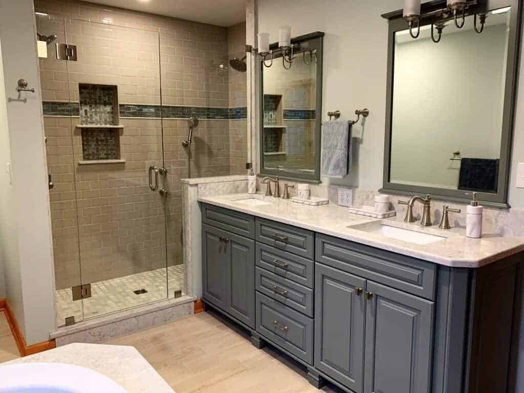 Elegant bathroom with double vanity, large mirrors, and walk-in shower.