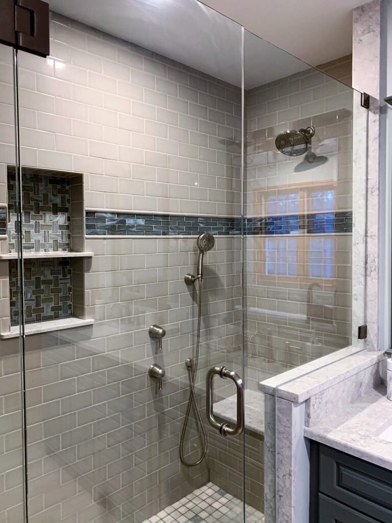 Modern tiled shower with glass enclosure and built-in niche.