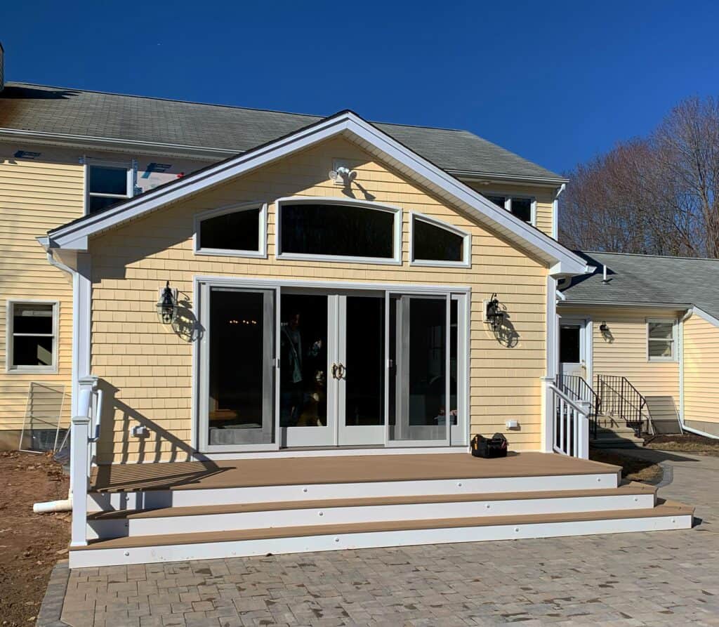 Spacious residential home featuring large glass sliding doors, a cozy porch, and elegant exterior li.