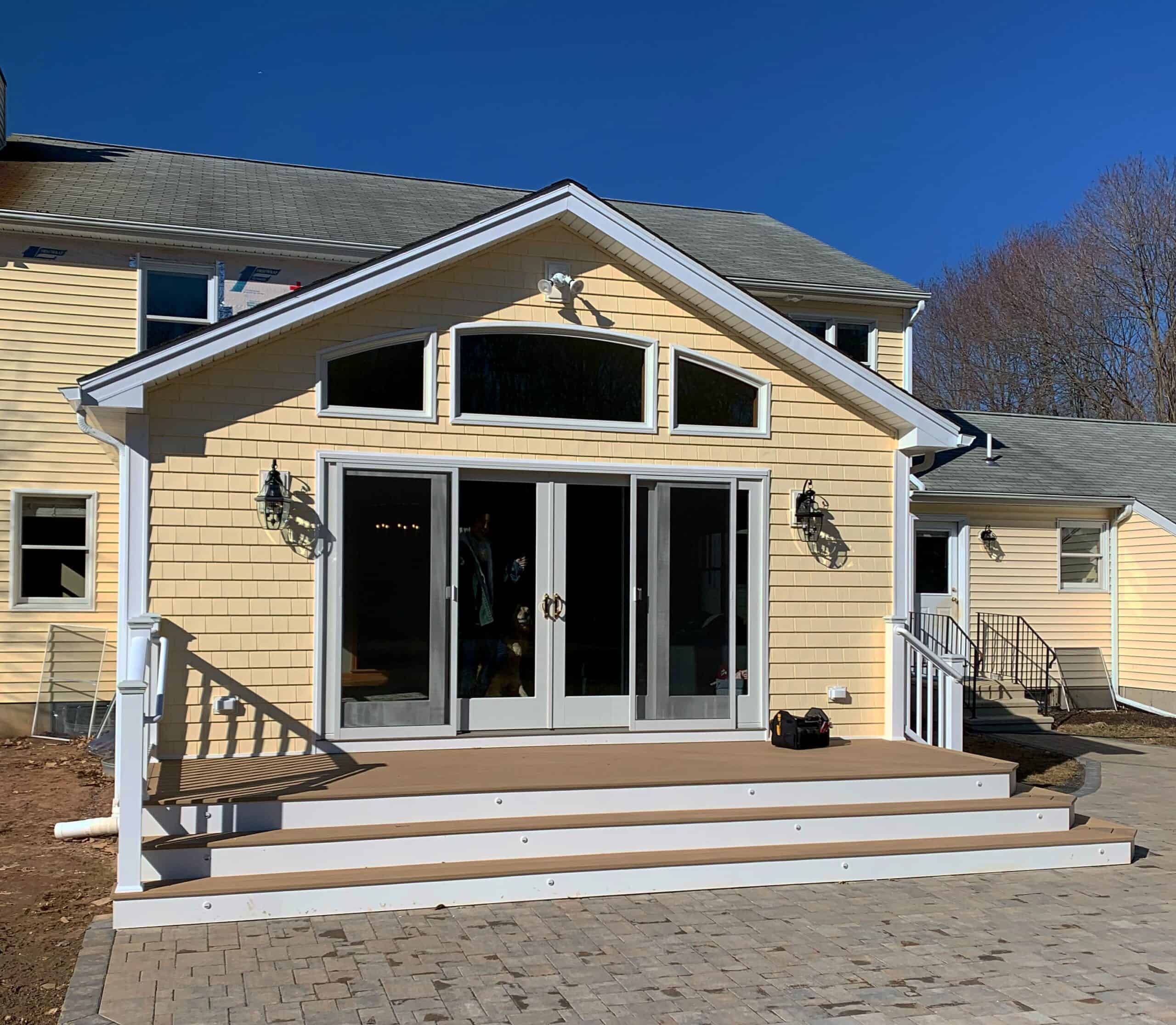 Spacious residential home featuring large glass sliding doors, a cozy porch, and elegant exterior li.