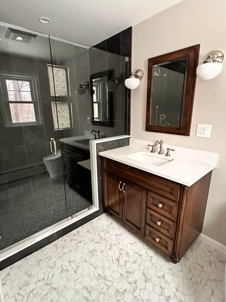 Modern bathroom with glass shower and wooden vanity, bright lighting, and elegant design.