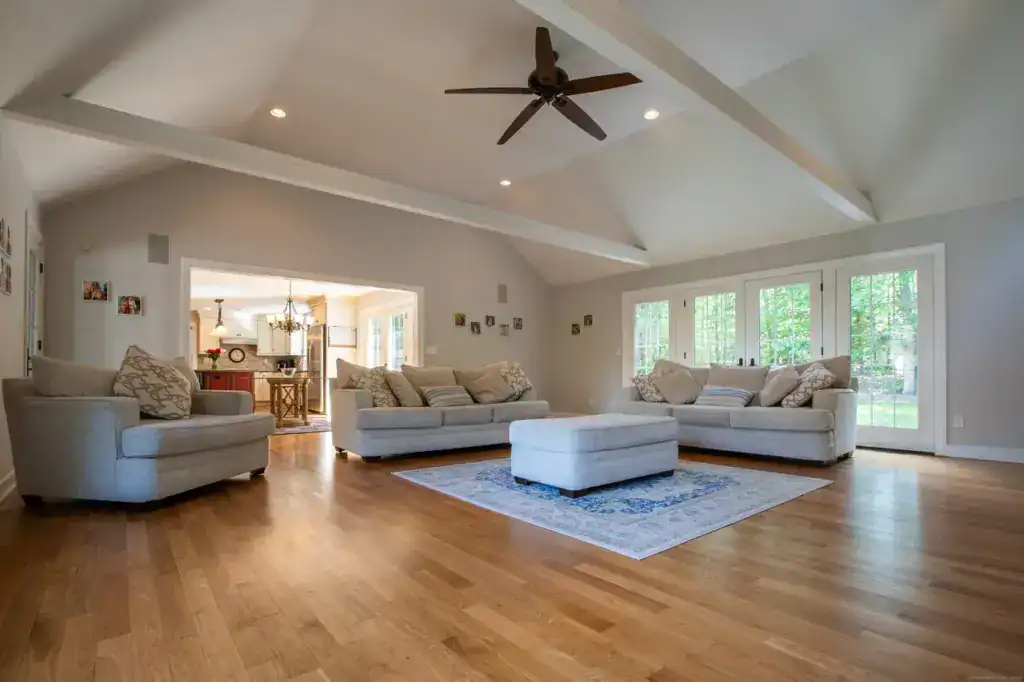 Bright and spacious living room with large windows, hardwood floors, and comfortable seating.