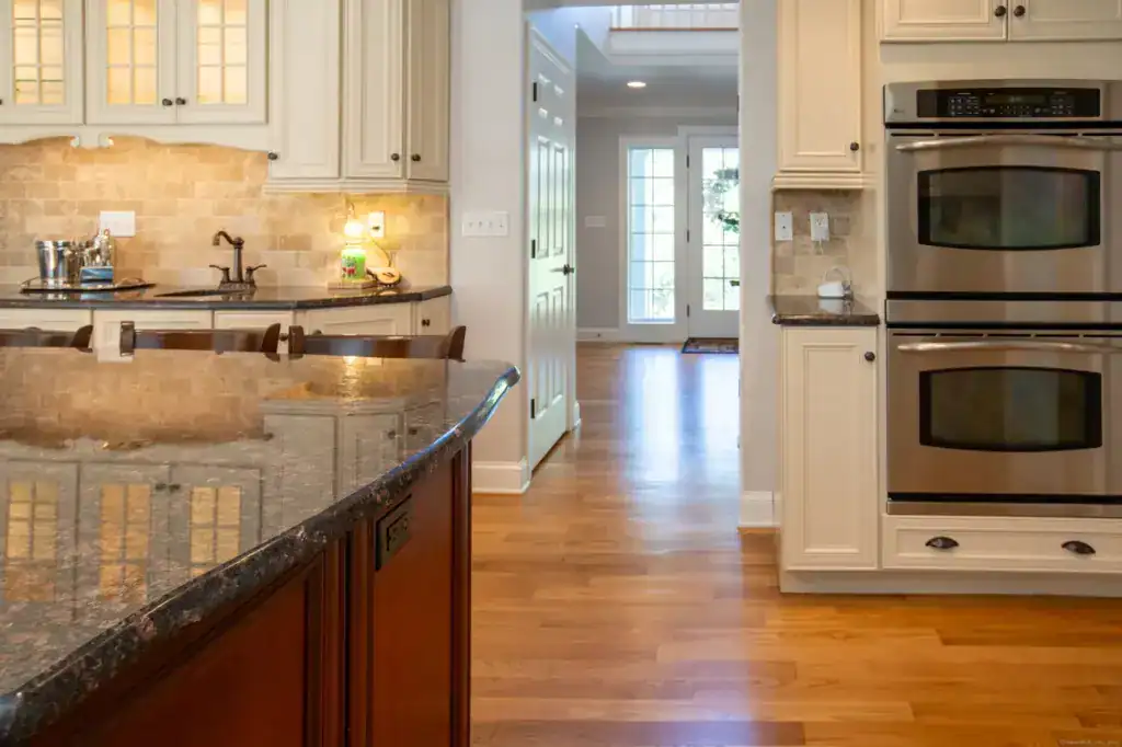 Bright modern kitchen with granite countertops and white cabinetry.
