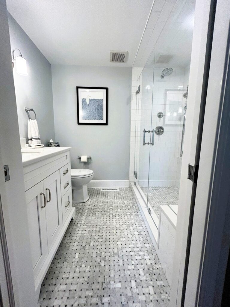 Bathroom with glass shower enclosure and white vanity.