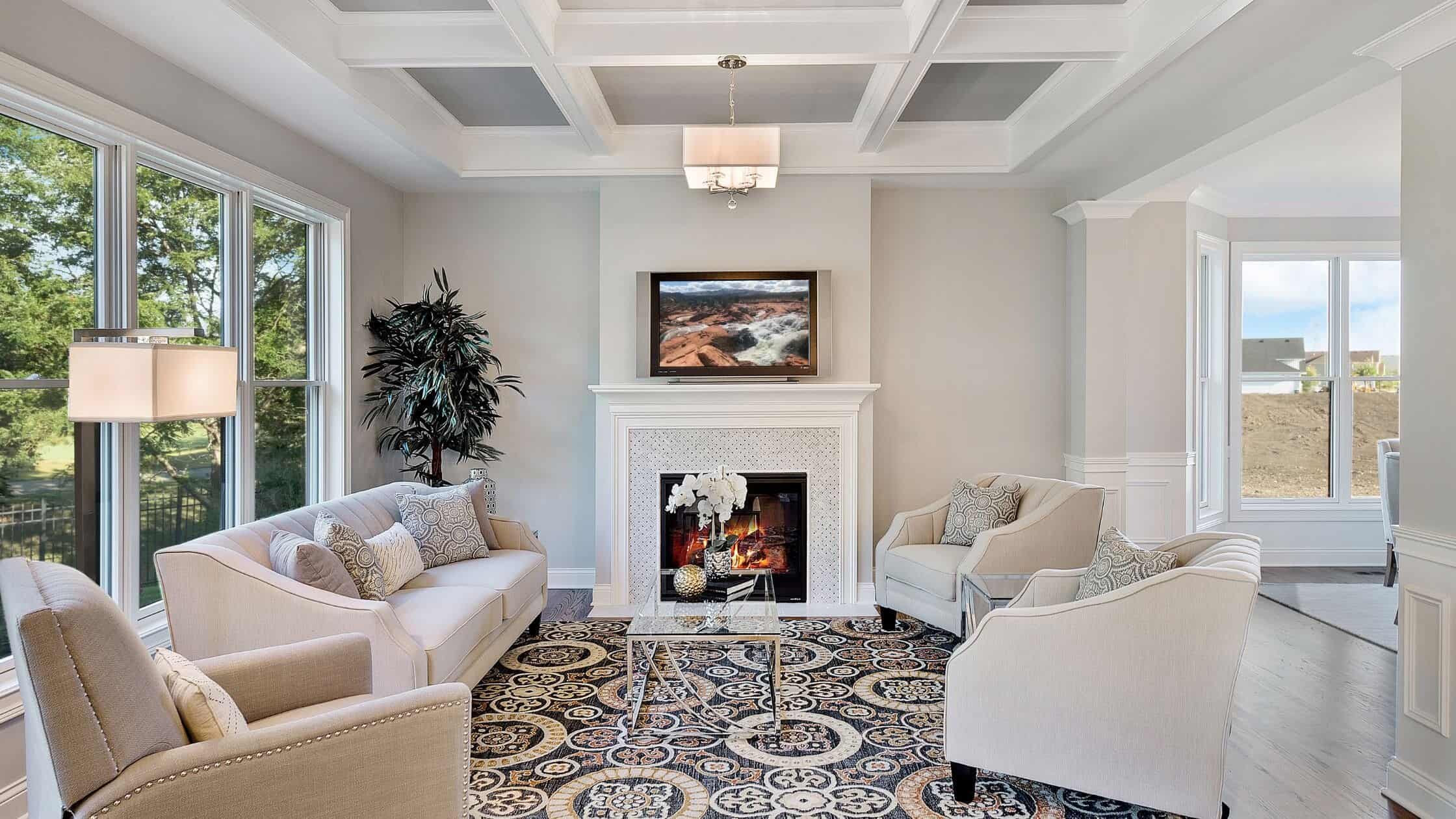 Bright and spacious living room with large windows, cozy fireplace, and stylish furniture. Perfect f.