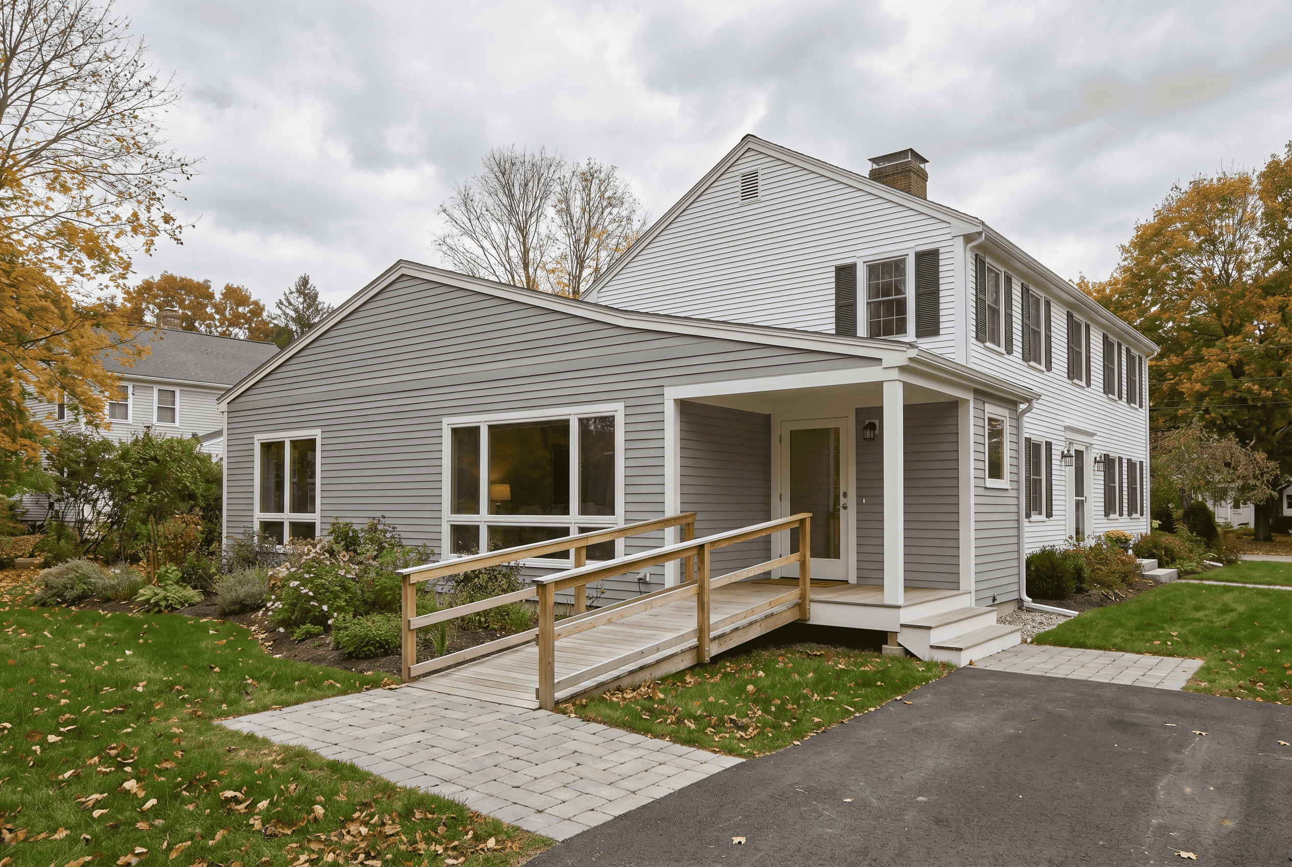 Modern two-story house with accessible ramp and landscaped yard in a suburban neighborhood.