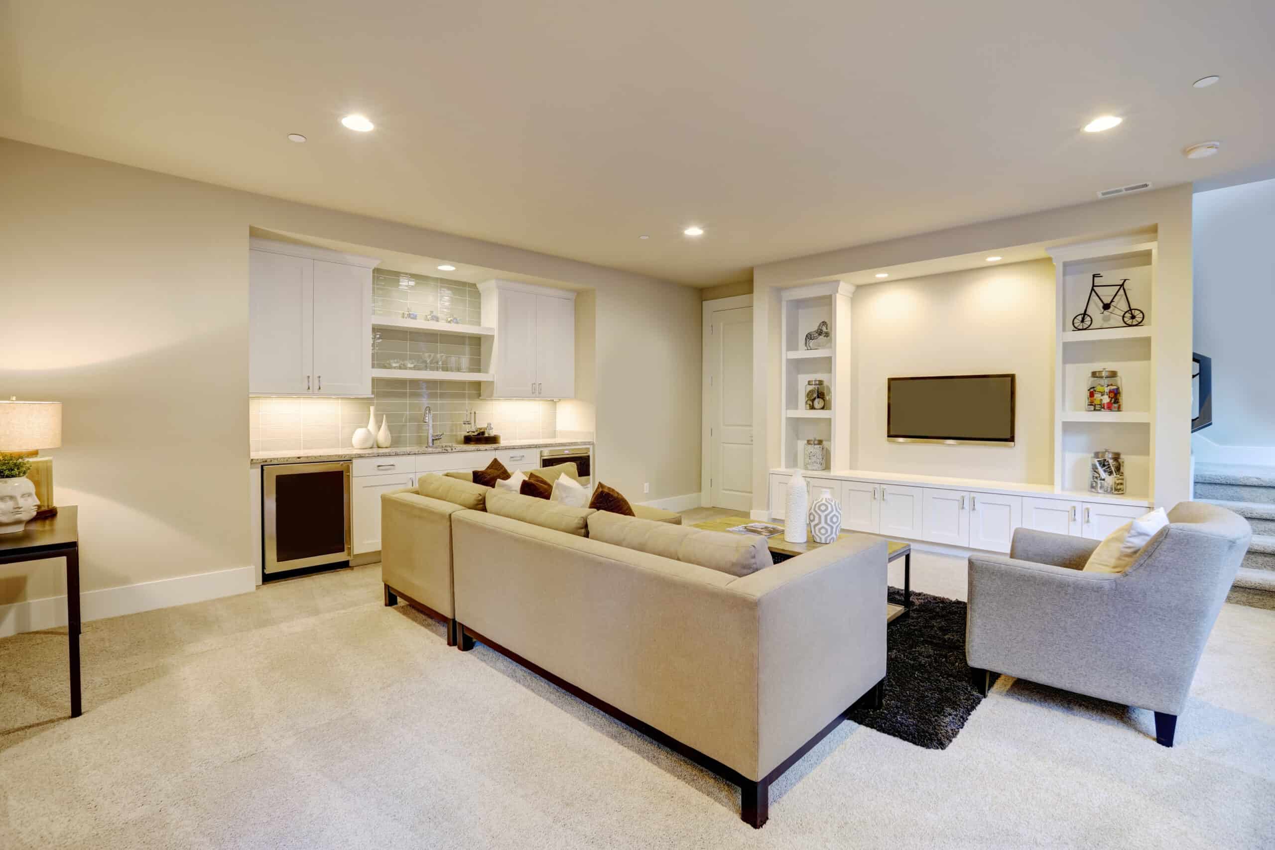 Spacious modern living room with beige sofas and built-in entertainment center.